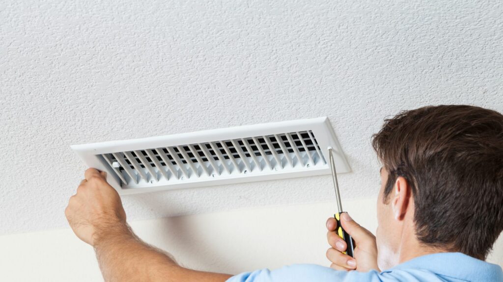 man removing heat vent cover for duct cleaning